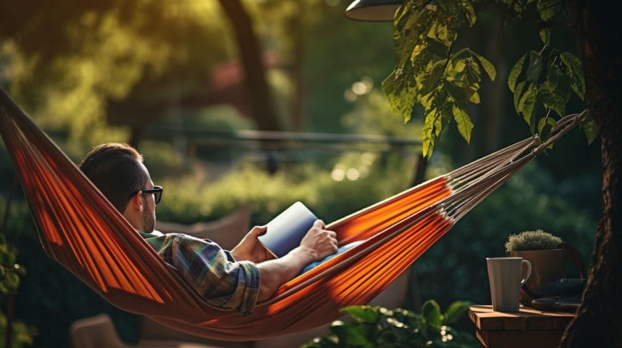 An individual relaxing in a hammock, surrounded by nature.