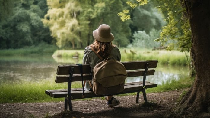A person sitting alone on a secluded bench in a serene natural setting.